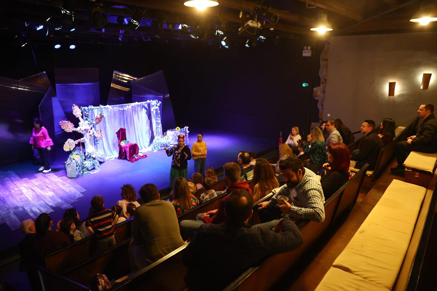 The theatre auditorium full, with the stage lit